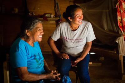Trabajadora comunitaria de salud realizando visita domiciliaria a un paciente